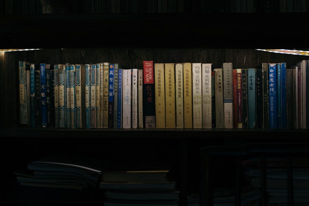 Old wooden library shelves filled with worn books in dim warm light