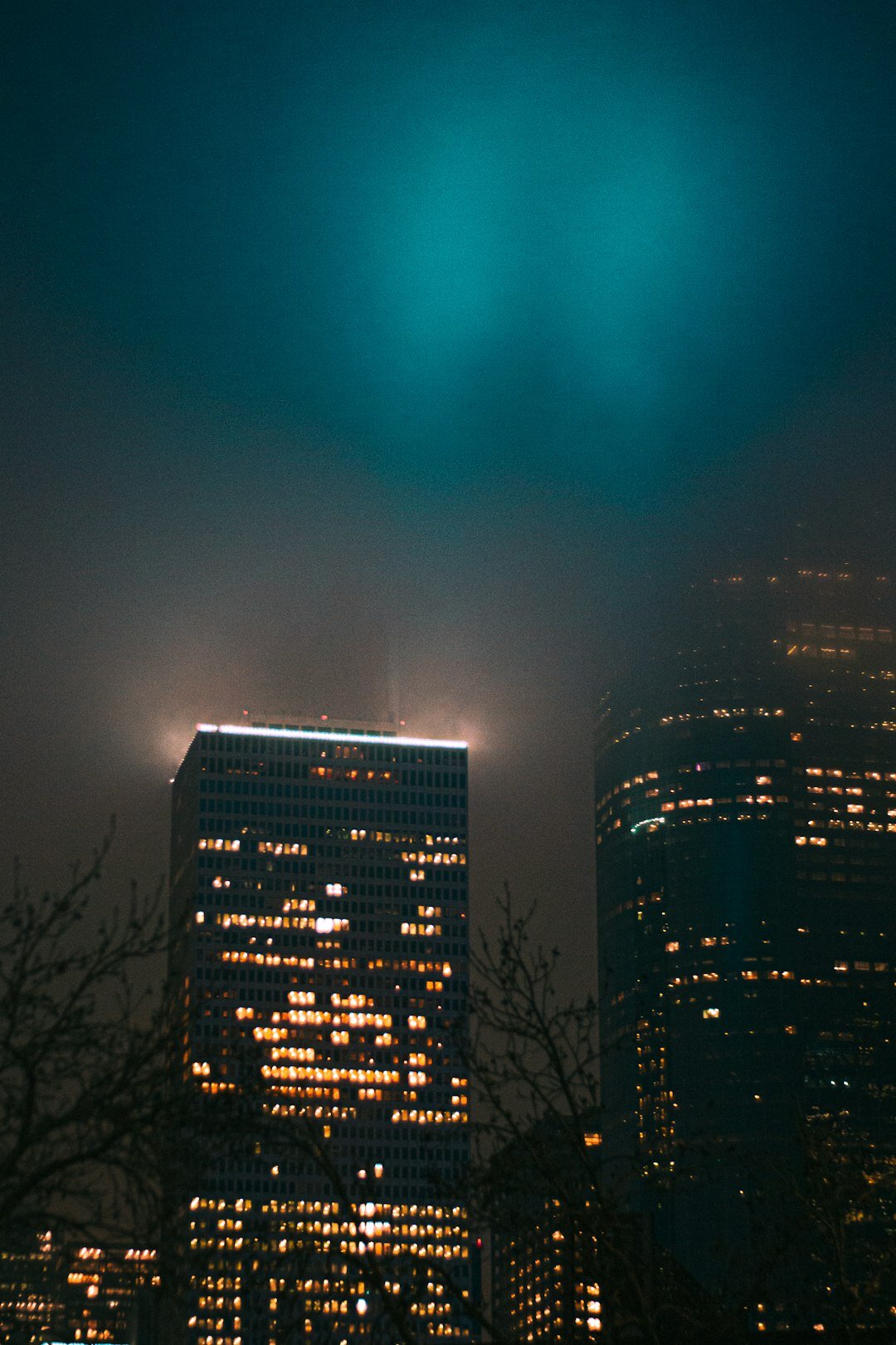 Dark mysterious book cover design with a foggy city skyline at night